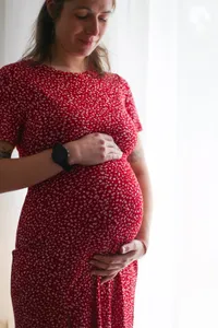 Solène, enceinte, en robe rouge